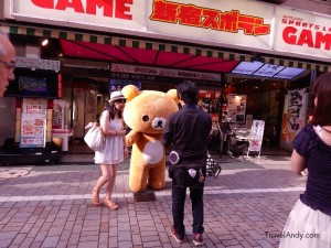 People take pictures with a person dressed as a cartoon character in Tokyo